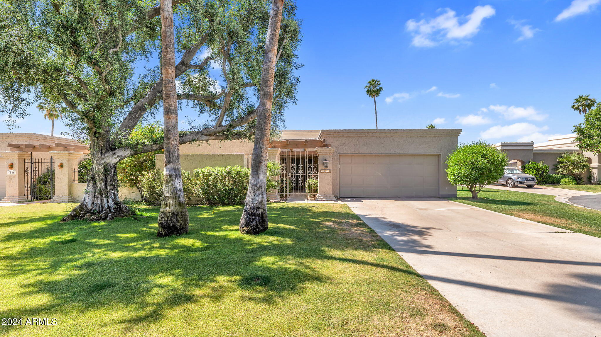 7819 East Vía Rio Scottsdale, AZ 85258 - Photo 42 of 42 a front view of a house with a yard and garage
