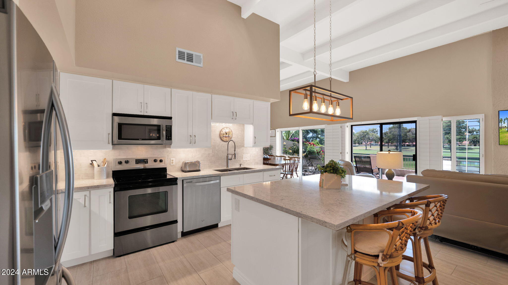 7819 East Vía Rio Scottsdale, AZ 85258 - Photo 9 of 42 a open kitchen with stainless steel appliances granite countertop a stove top oven a refrigerator a sink dishwasher a dining table and chairs with wooden floor