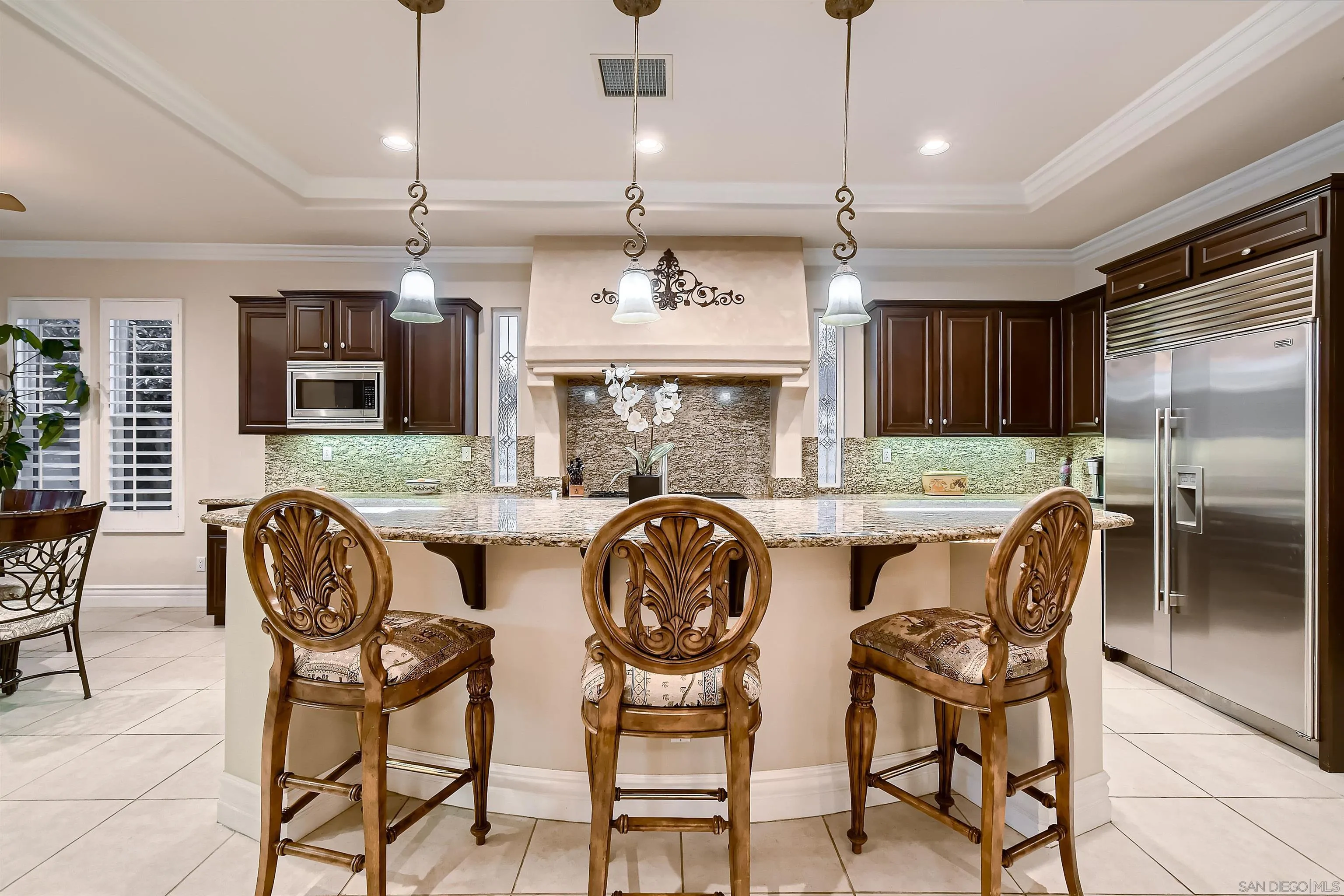 3349 Mendenaro Court Fallbrook, CA 92028 - Photo 15 of 31 a kitchen with stainless steel appliances granite countertop a stove a refrigerator a kitchen island a dining table and chairs with wooden floor