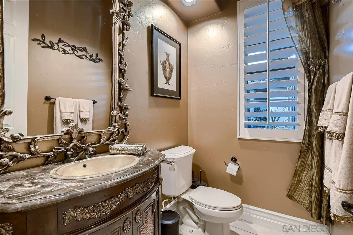 3349 Mendenaro Court Fallbrook, CA 92028 - Photo 18 of 34 a bathroom with a sink a toilet a mirror and shower