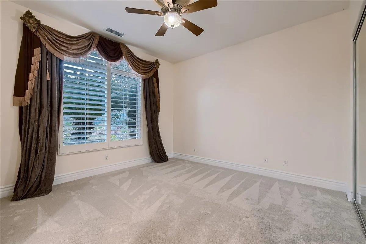 3349 Mendenaro Court Fallbrook, CA 92028 - Photo 19 of 34 a view of an empty room with a ceiling fan and a window