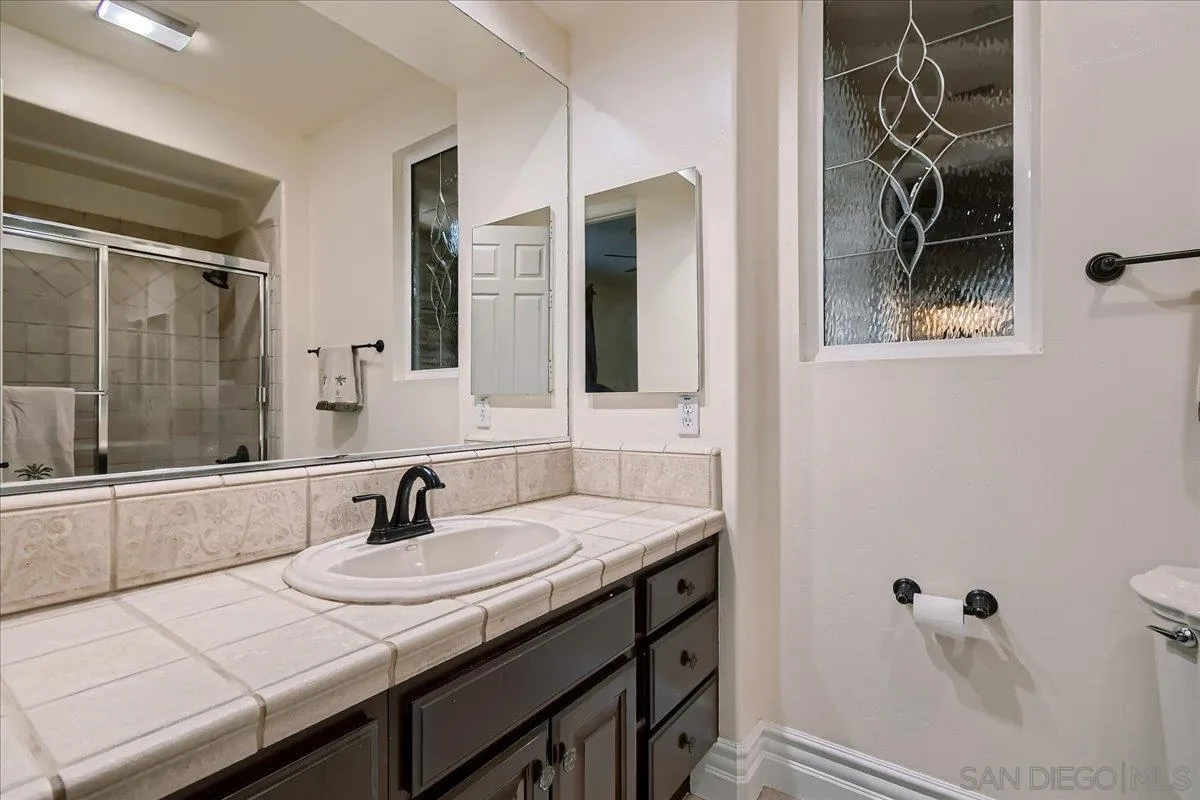 3349 Mendenaro Court Fallbrook, CA 92028 - Photo 20 of 34 a bathroom with a sink and mirror with bathtub