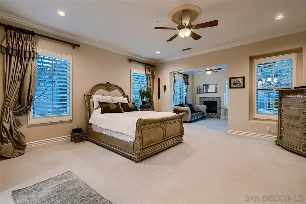 3349 Mendenaro Court Fallbrook, CA 92028 - Photo 22 of 34 a bedroom with a bed and a chandelier