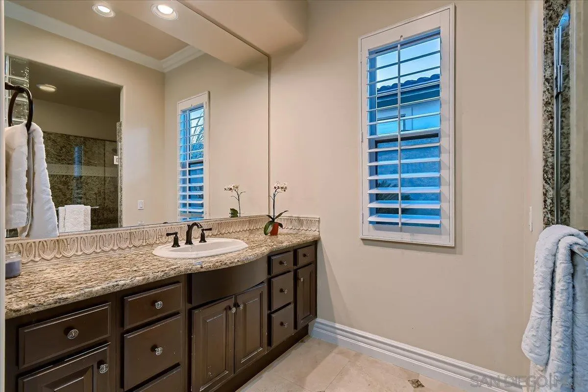 3349 Mendenaro Court Fallbrook, CA 92028 - Photo 26 of 34 a bathroom with a granite countertop sink and a mirror