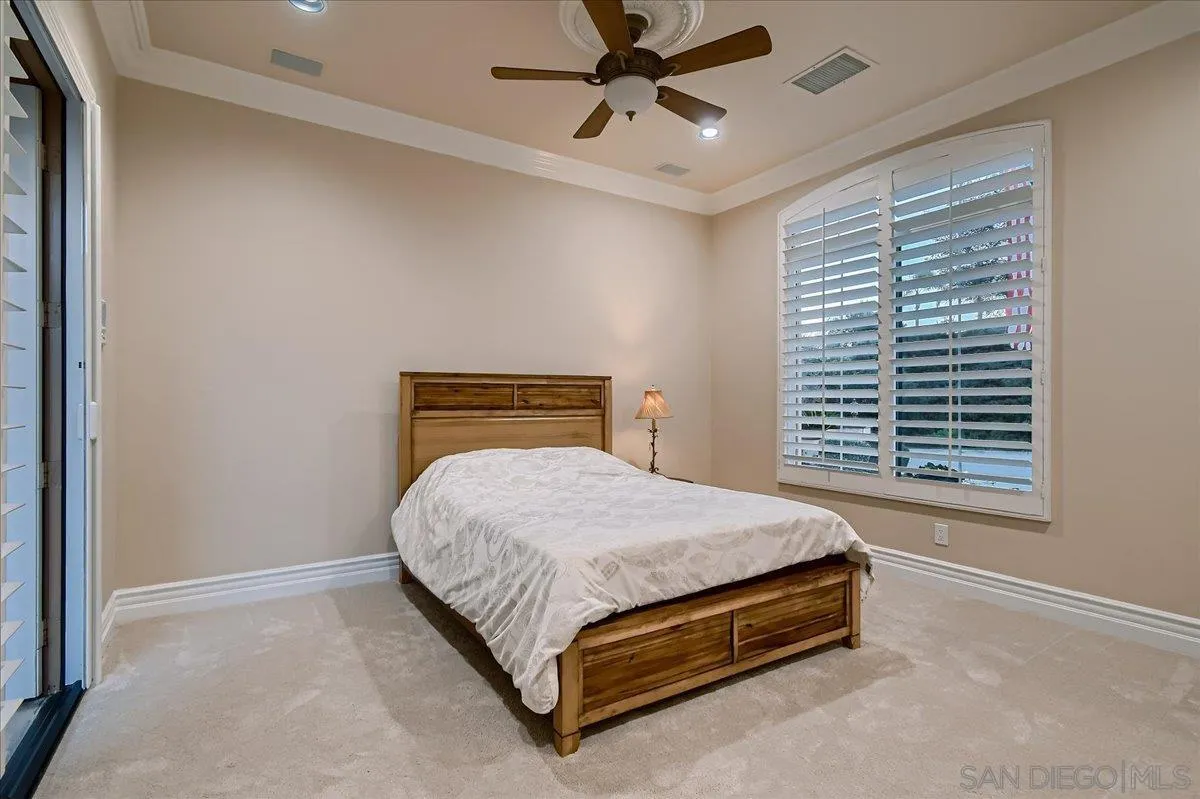 3349 Mendenaro Court Fallbrook, CA 92028 - Photo 28 of 34 a bedroom with a bed lamp and window
