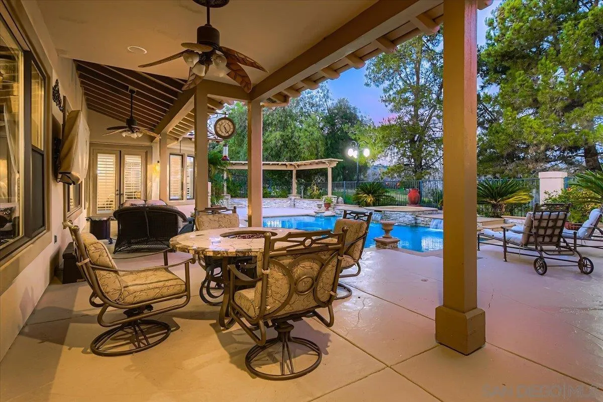 3349 Mendenaro Court Fallbrook, CA 92028 - Photo 30 of 34 a view of a patio with a table chairs and a floor to ceiling window