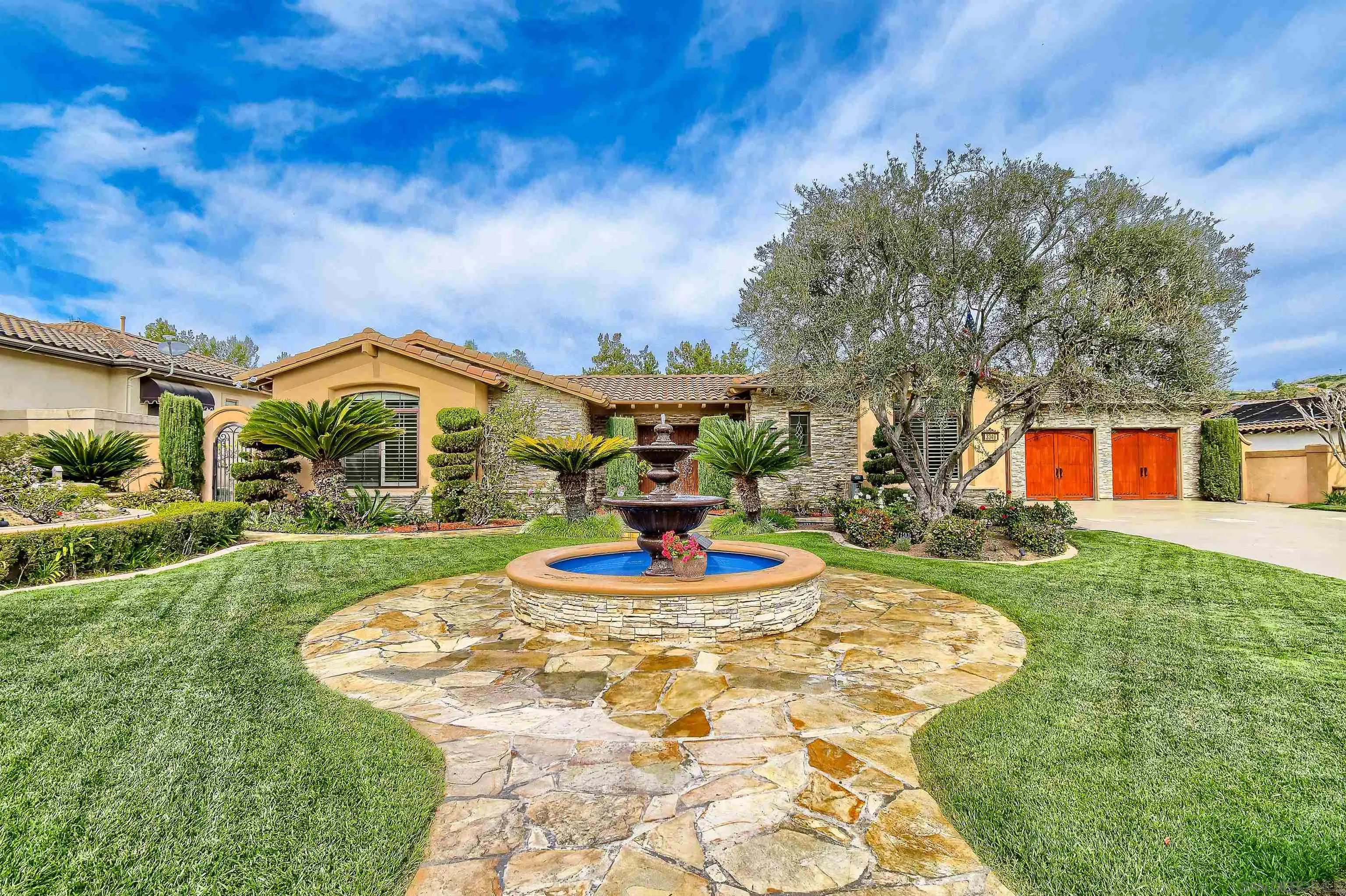 3349 Mendenaro Court Fallbrook, CA 92028 - Photo 5 of 31 a front view of a house with a yard fountain and large tree