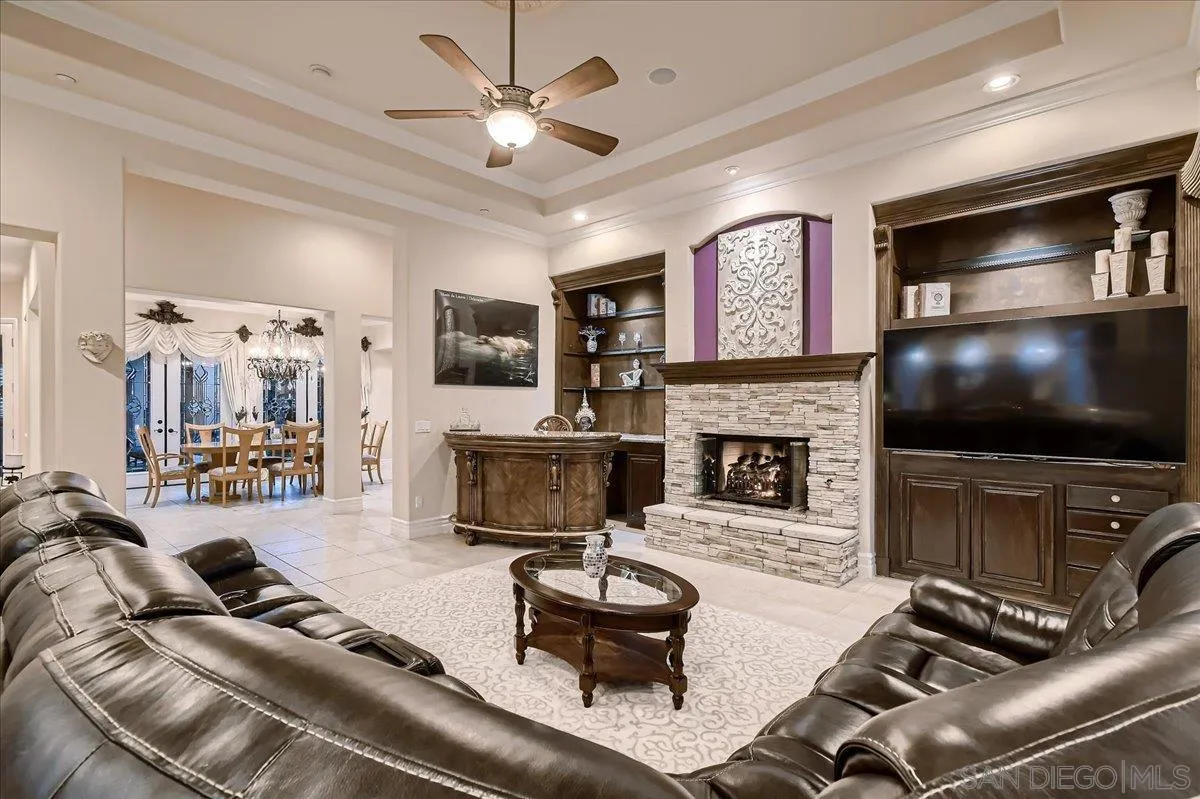 3349 Mendenaro Court Fallbrook, CA 92028 - Photo 10 of 34 a living room with furniture a flat screen tv and a fireplace
