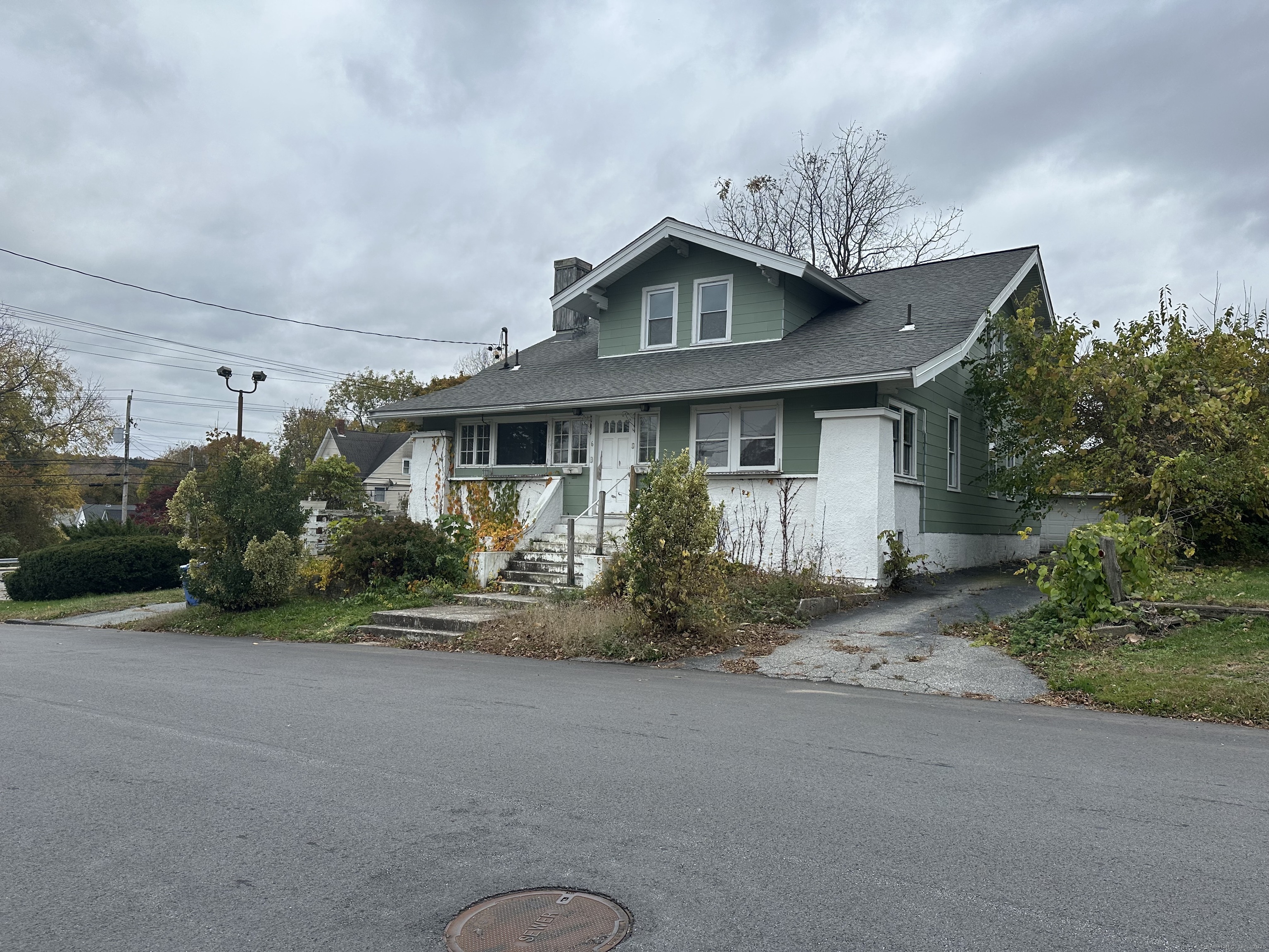 a view of a house next to a yard with plants and trees