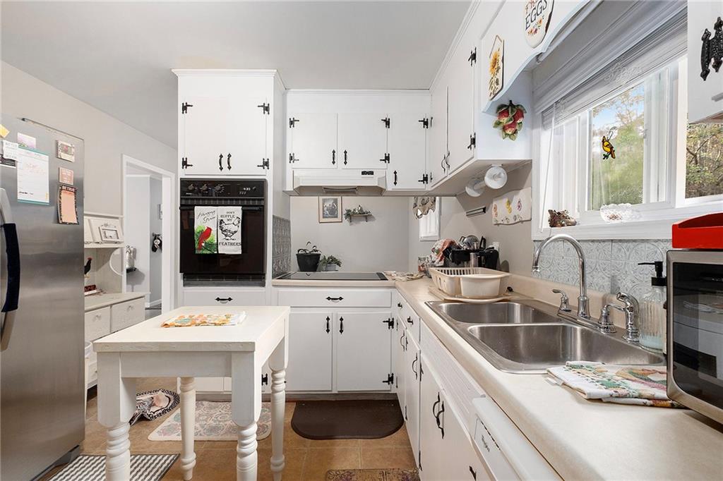 1246 Duncan Bridge Road Cornelia, GA 30531 - Photo 10 of 21 a kitchen that has a sink a stove and a table in it