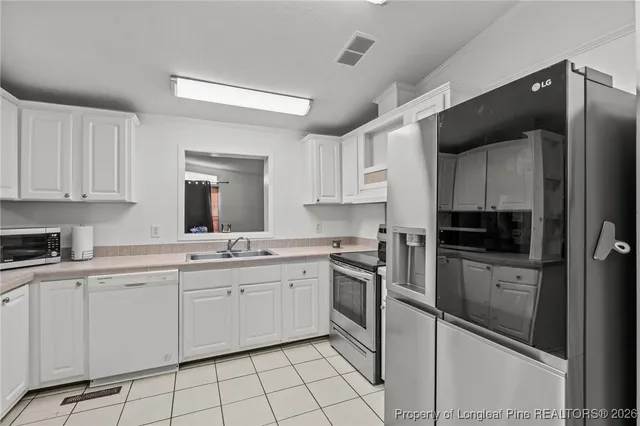 a kitchen with granite countertop white cabinets and appliances