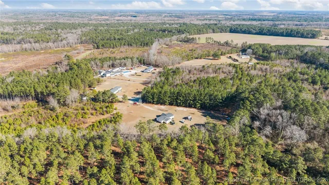 a view of a white house with a yard and sitting area