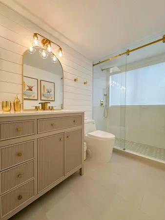 a spacious bathroom with a double vanity sink toilet mirror and bathtub