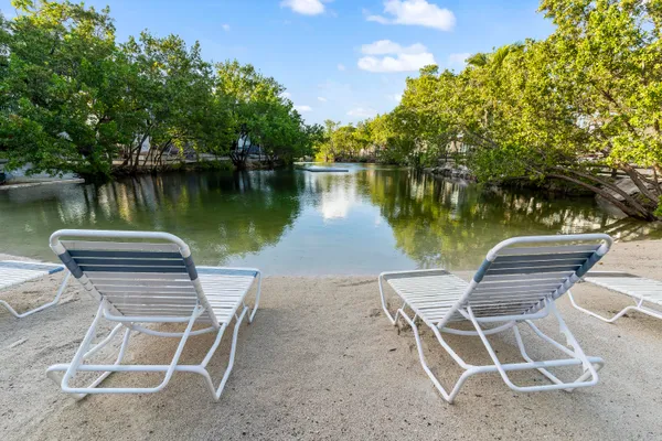 a view of a lake with a table and chairs in the patio