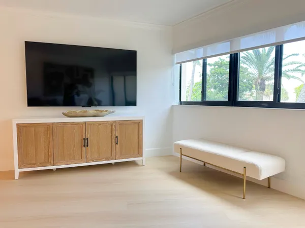 a living room with a flat screen tv and a ceiling fan