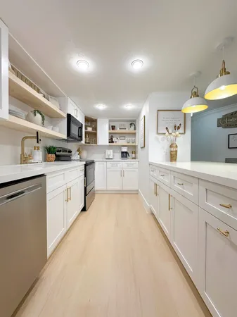 a large white kitchen with stainless steel appliances granite countertop lots of counter top space