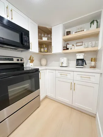 a kitchen with white cabinets stainless steel appliances and sink