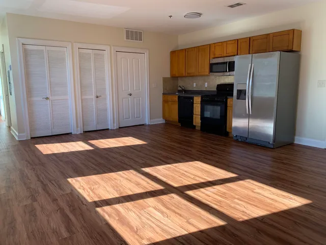 a kitchen with granite countertop a refrigerator and a sink