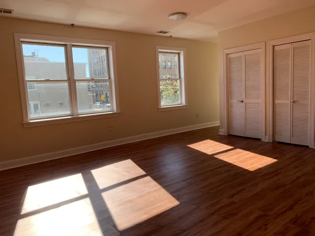a view of a room with wooden floor and windows