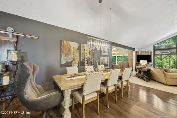 a dining room with furniture a chandelier and wooden floor