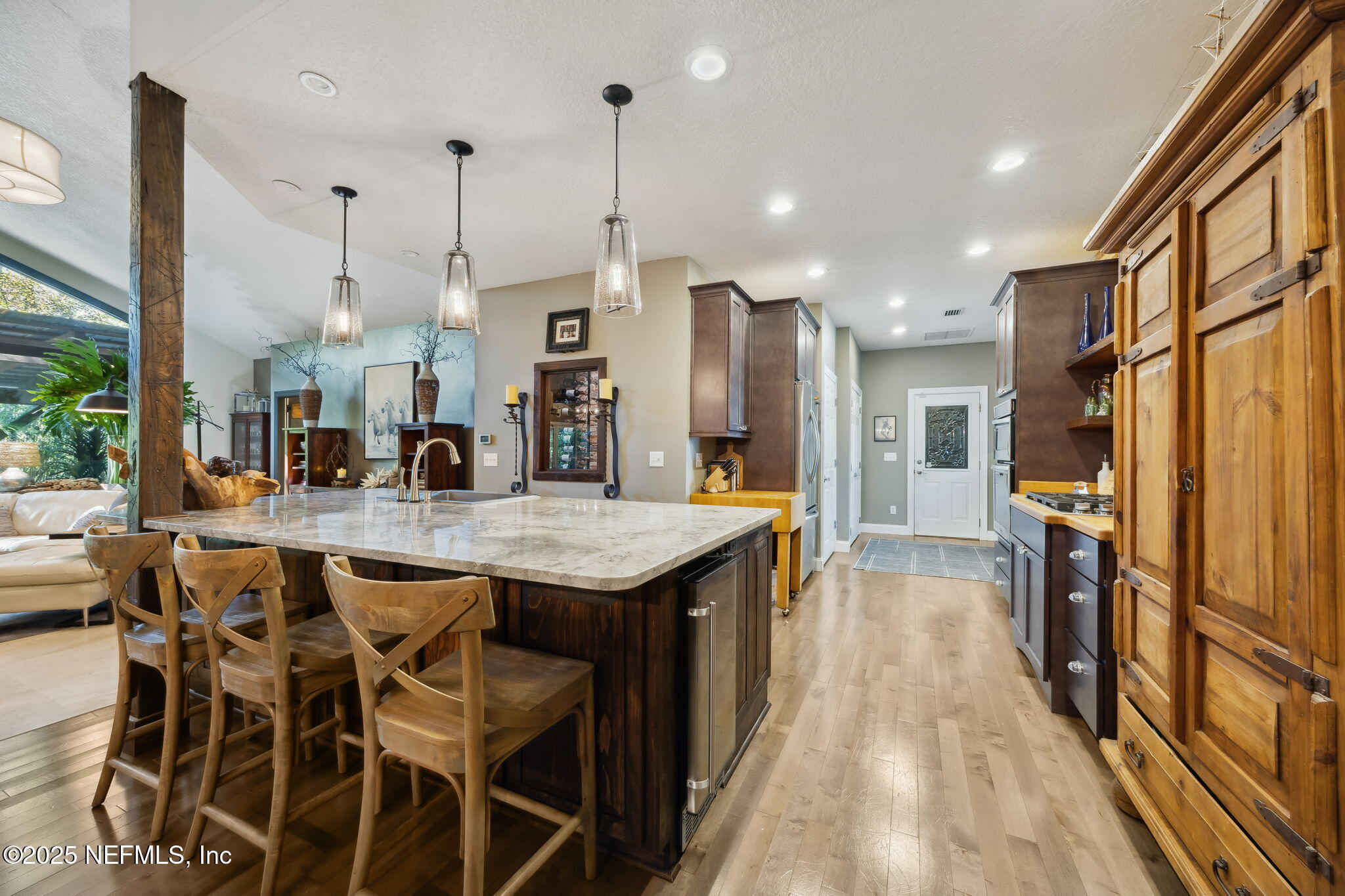 2245 Reed Street Orange Park, FL 32073 - Photo 26 of 107 a kitchen with stainless steel appliances kitchen island granite countertop a table chairs and a wooden floor