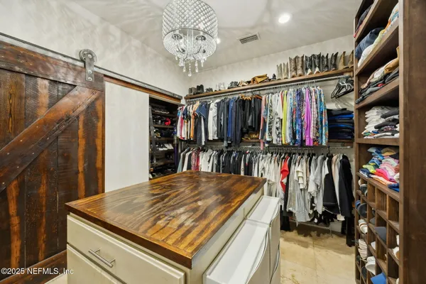 a view of walk in closet with clothes