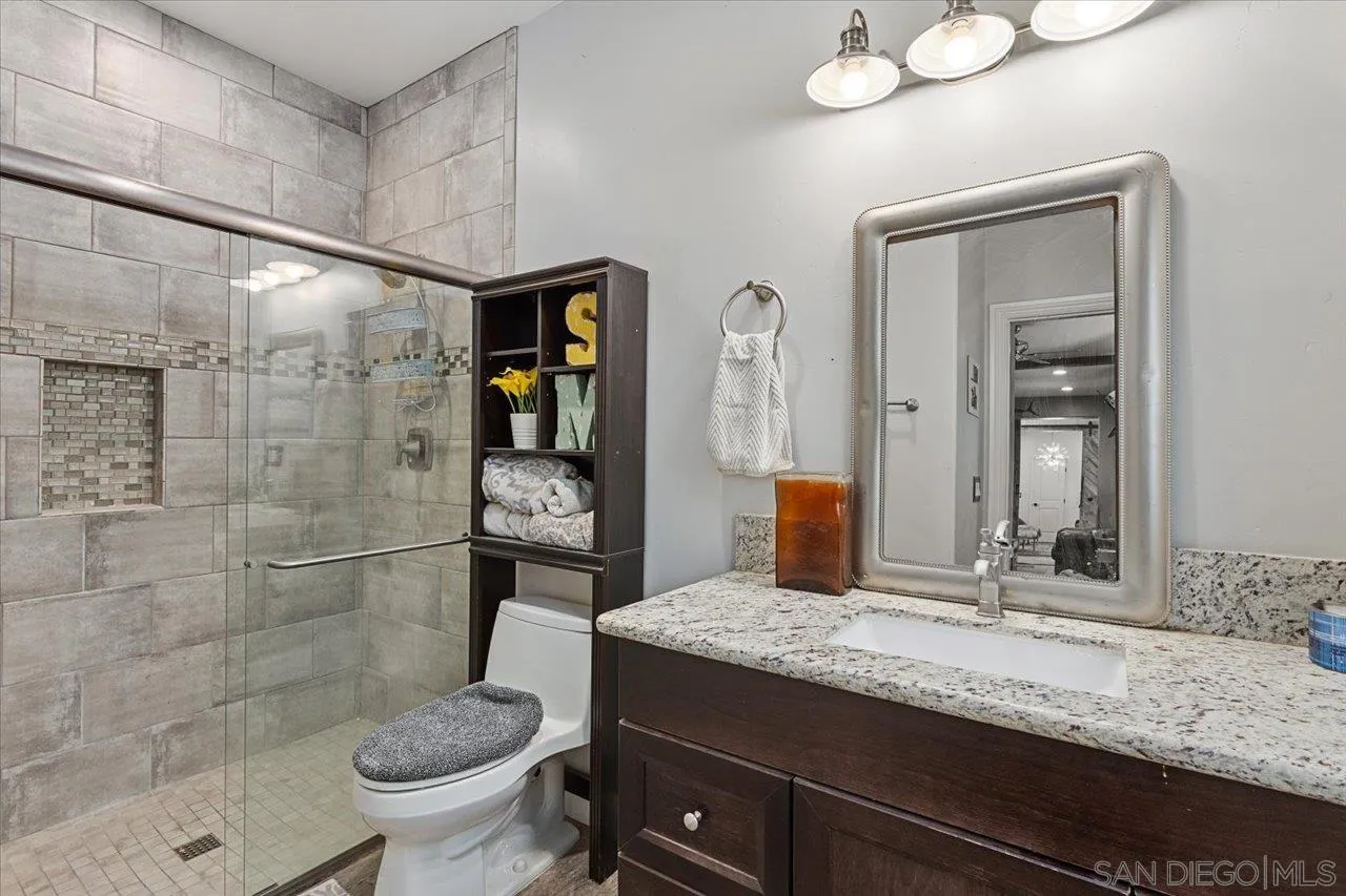 15786 Olde Highway 80 El Cajon, CA 92021 - Photo 19 of 75 a bathroom with a granite countertop sink a toilet and shower