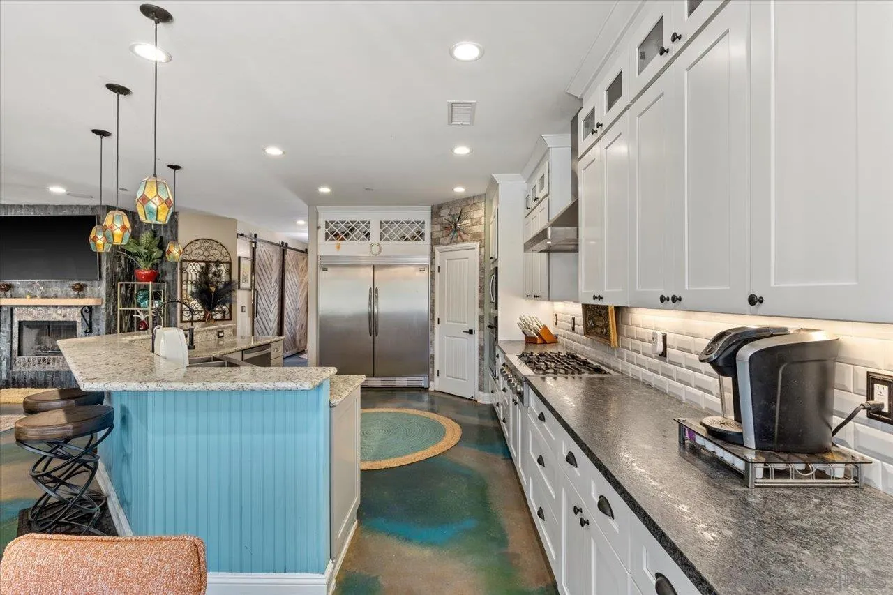 15786 Olde Highway 80 El Cajon, CA 92021 - Photo 30 of 75 a kitchen with kitchen island granite countertop a sink a counter top space appliances and cabinets