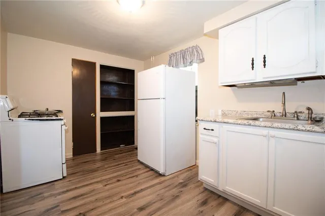 a view of kitchen with wooden floor and electronic appliances