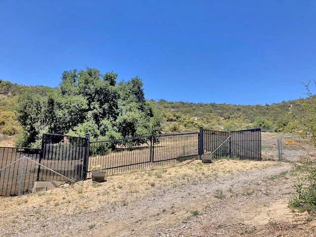 a view of a yard with wooden fence