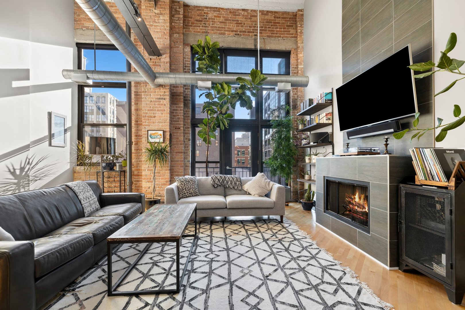 203 South Sangamon Street, Unit 306 Chicago, IL 60607 - Photo 4 of 30 a living room with furniture a fireplace a flat screen tv and a floor to ceiling window
