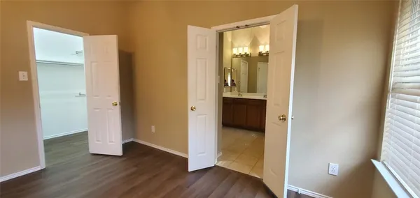 an empty room with wooden floor and a window