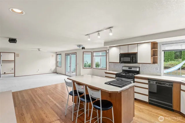 a large kitchen with a large window and stainless steel appliances