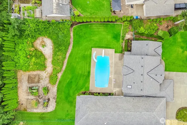 an aerial view of a house with a garden and trees