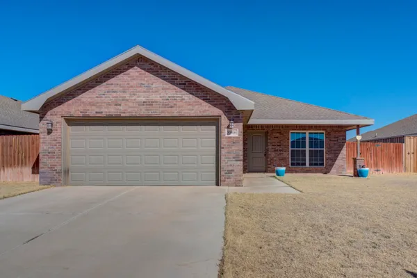 a front view of a house with a garage and a yard