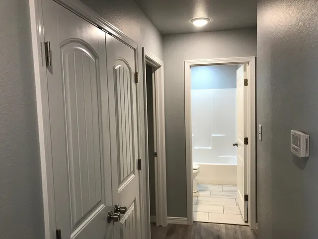 a view of a hallway with windows and closet