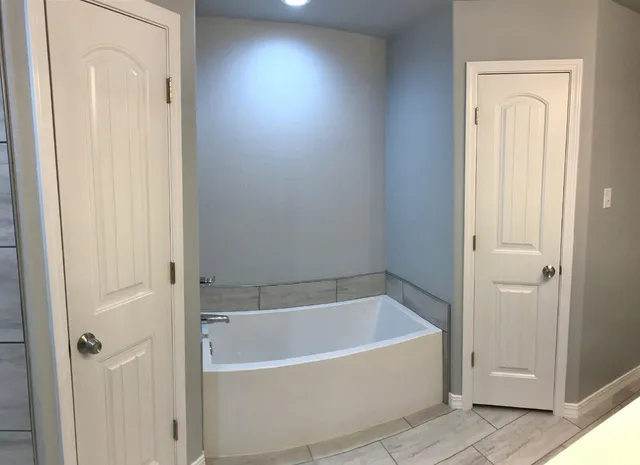 a white bath tub sitting next to a shower