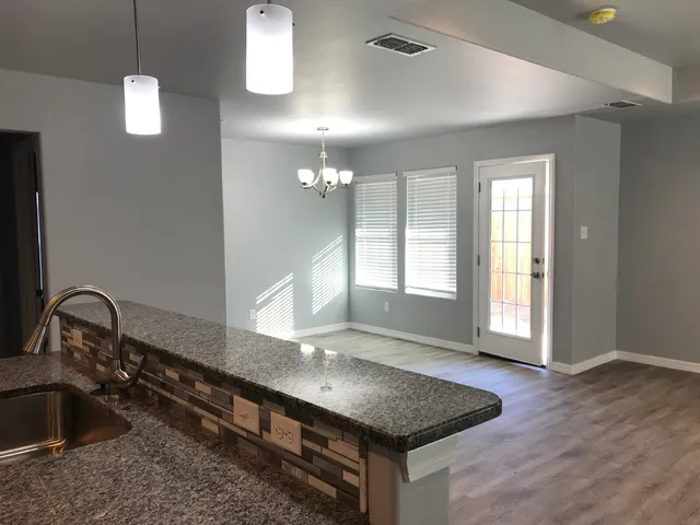 a kitchen with a sink granite counter tops and a window