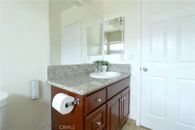 a bathroom with a granite countertop sink and a mirror