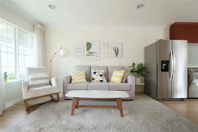 a living room with furniture a refrigerator and a table