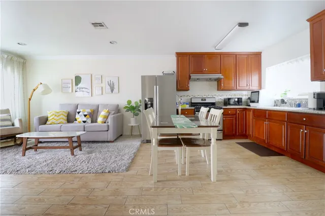 a living room with stainless steel appliances granite countertop furniture and a kitchen view