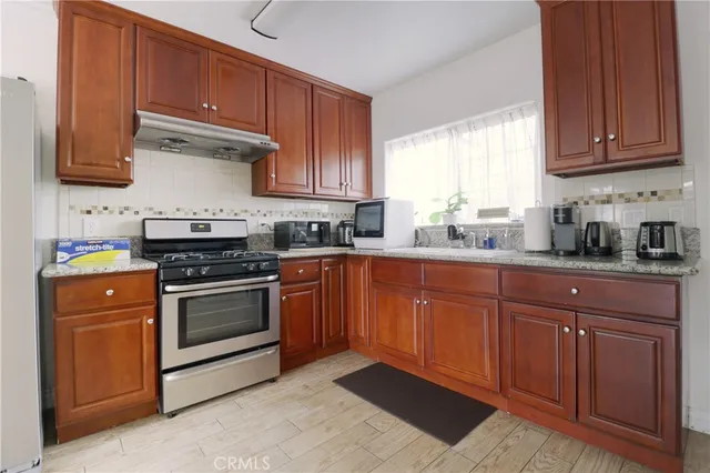 a kitchen with granite countertop wooden cabinets and white appliances