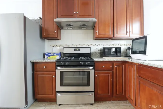 a kitchen with stainless steel appliances granite countertop a stove and a refrigerator