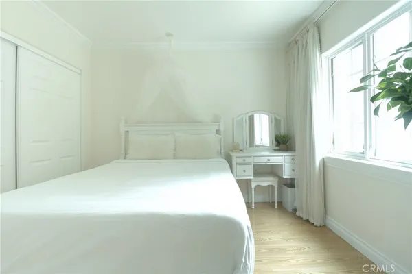 a bedroom with a bed and a potted plant