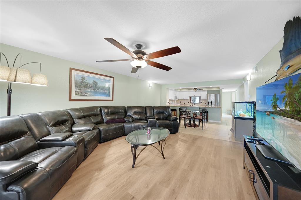 240 Lewis Circle, Unit 513 Punta Gorda, FL 33950 - Photo 12 of 45 a living room with furniture and a flat screen tv with kitchen view