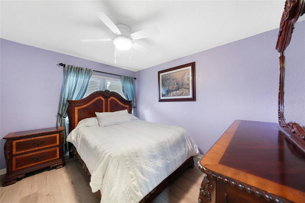 240 Lewis Circle, Unit 513 Punta Gorda, FL 33950 - Photo 21 of 45 a bedroom with a bed and a chandelier