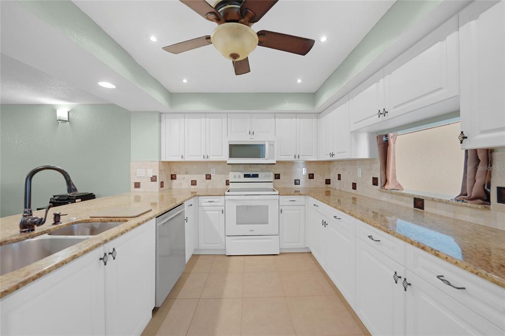 240 Lewis Circle, Unit 513 Punta Gorda, FL 33950 - Photo 7 of 45 a large white kitchen with stainless steel appliances granite countertop a sink and cabinets