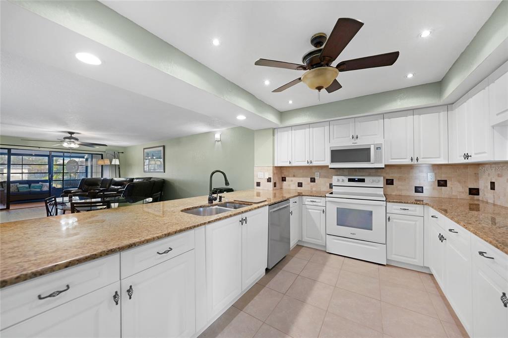240 Lewis Circle, Unit 513 Punta Gorda, FL 33950 - Photo 8 of 45 a kitchen with granite countertop a sink stainless steel appliances and cabinets