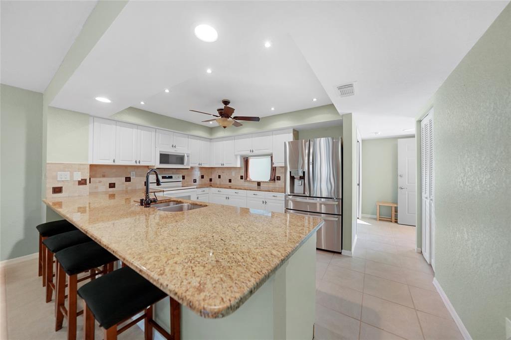240 Lewis Circle, Unit 513 Punta Gorda, FL 33950 - Photo 9 of 45 a large kitchen with kitchen island a table and chairs