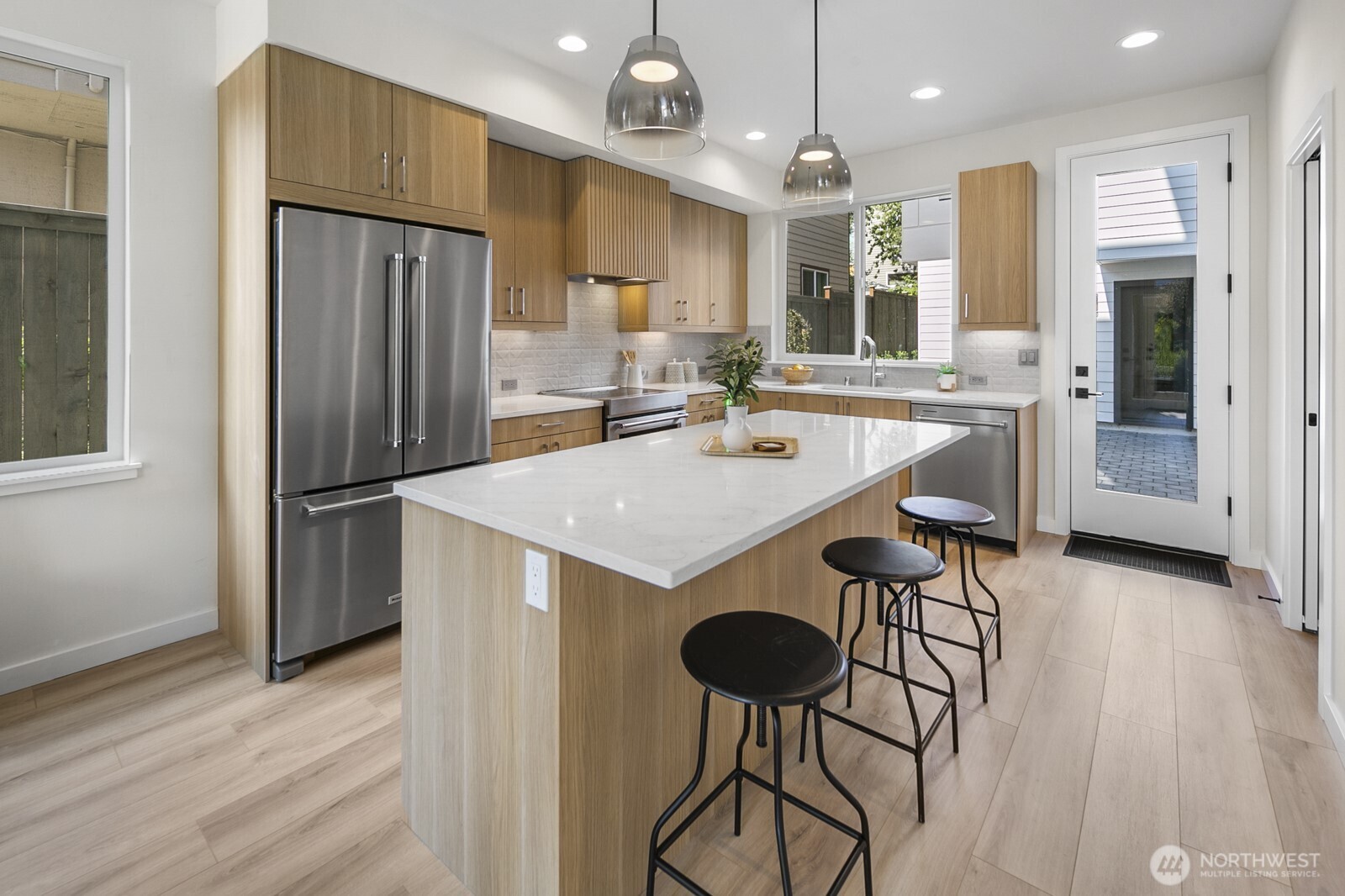 1748 Northwest 62nd Street Seattle, WA 98107 - Photo 5 of 33 a kitchen with a refrigerator a stove and a wooden floor